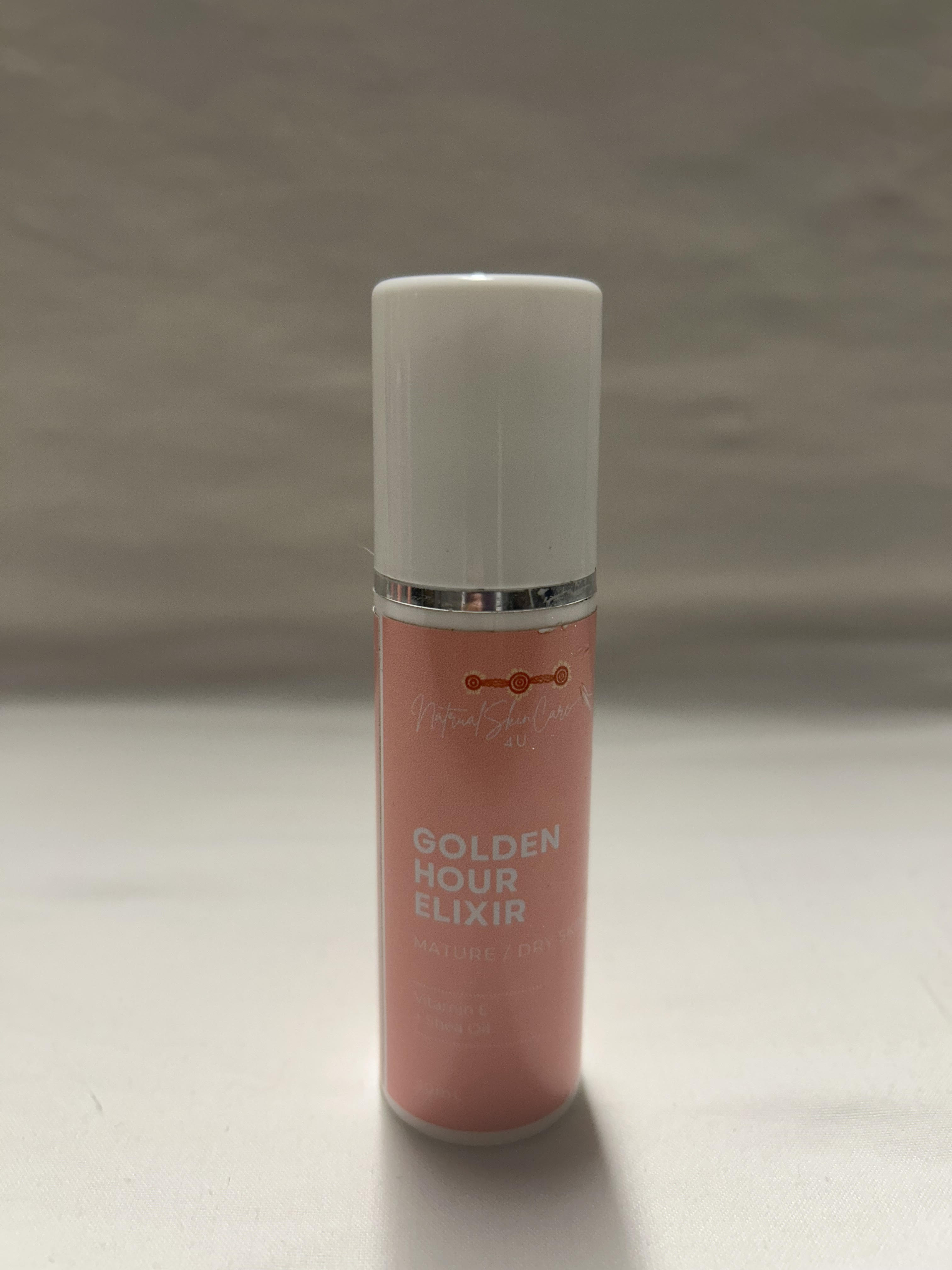 Pink bottle labeled 'Golden Hour Elixir' on a gray background